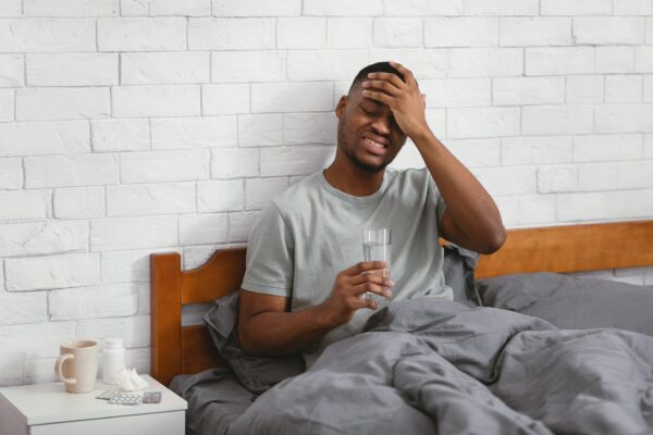 Sick Black Man Having Fever During Influenza Illness In Bedroom