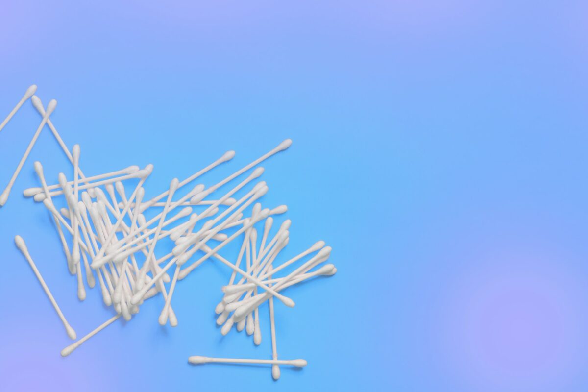 Ear sticks on blue purple background. Makeup removal and skin care concept. Space for text