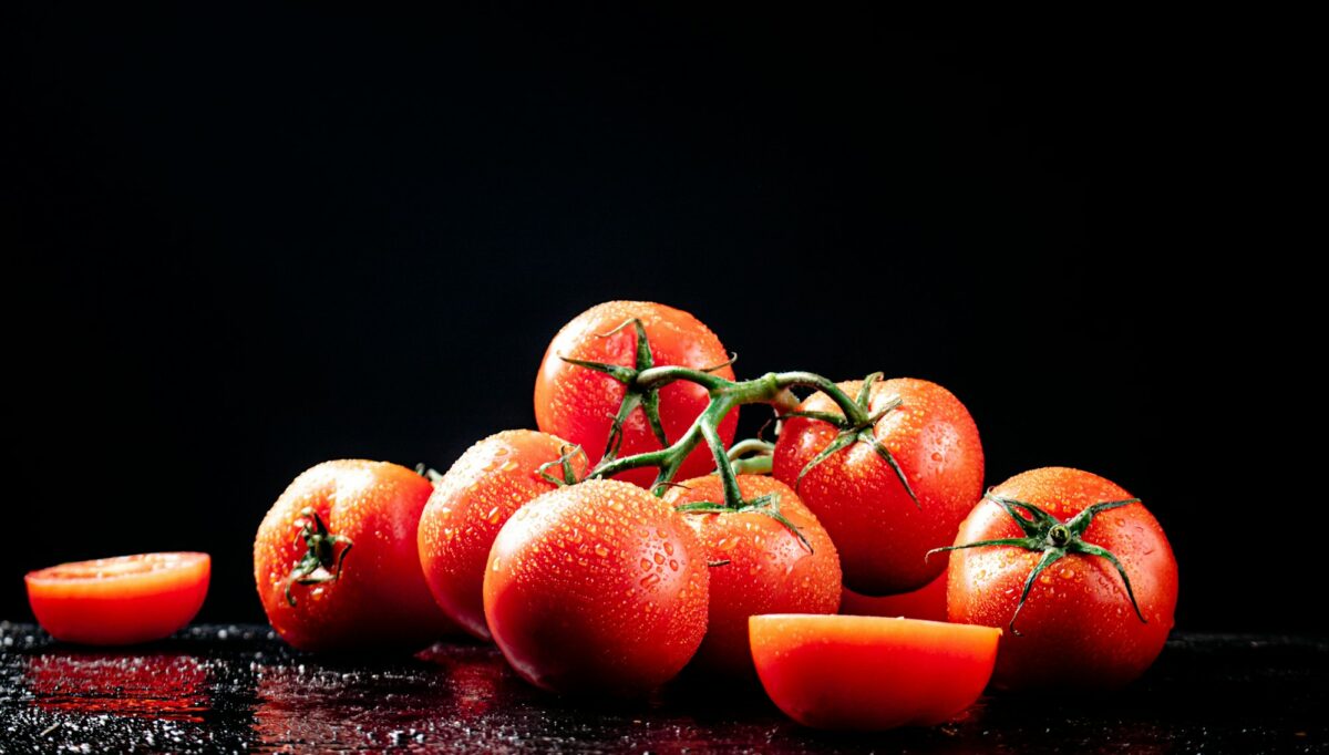 Ripe tomatoes on a branch and tomato halves.