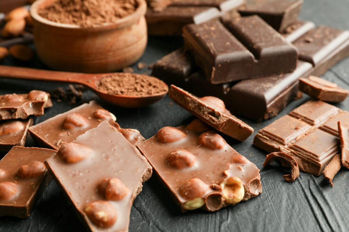 Chocolate, melted chocolate and almond on black background