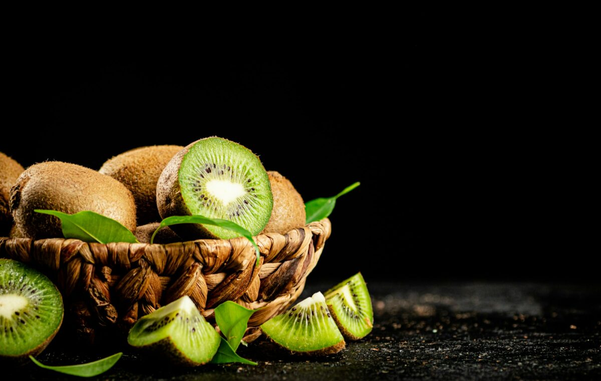 Fresh kiwi with leaves in a basket.