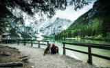Active man and dog looking at Pragser Wildsee or Braies Lake