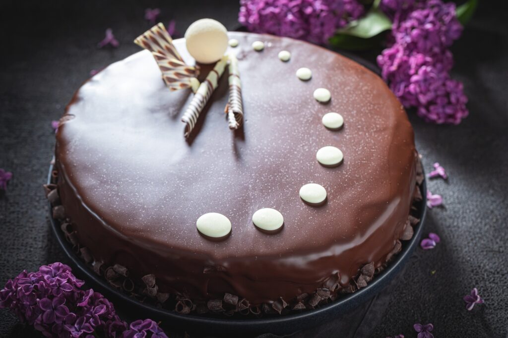 Dark chocolate cake with summer flowers. Sweet chocolate dessert.